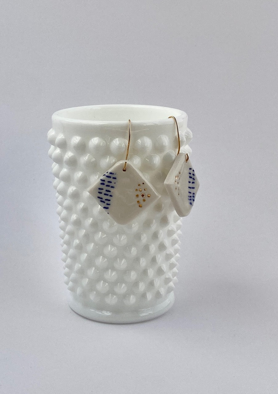Porcelain geometric earring with 22 karat gold accents.